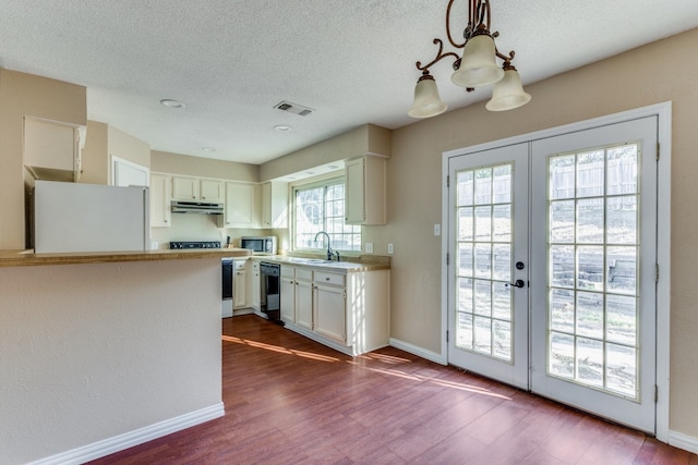 kitchen featuring white cabinetry, dishwasher, sink, hanging light fixtures, and stove