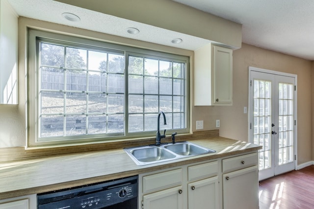 kitchen featuring white cabinetry, dishwasher, sink, hardwood / wood-style flooring, and french doors