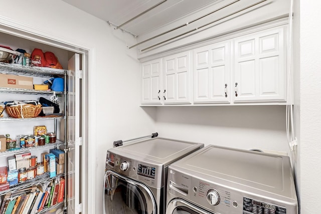 clothes washing area featuring independent washer and dryer and cabinets