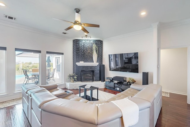 living room featuring dark hardwood / wood-style flooring, a fireplace, and ornamental molding