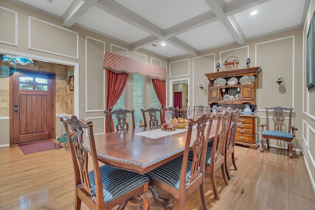 dining area featuring light hardwood / wood-style flooring, beamed ceiling, and coffered ceiling