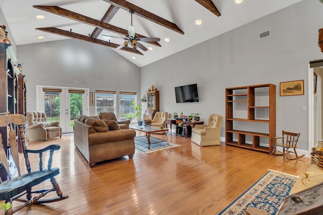 living room with ceiling fan, beam ceiling, high vaulted ceiling, light wood-type flooring, and french doors