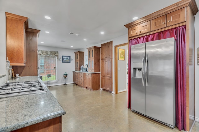 kitchen with light stone countertops and appliances with stainless steel finishes