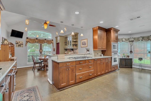 kitchen with light stone counters, stainless steel appliances, pendant lighting, vaulted ceiling, and ceiling fan