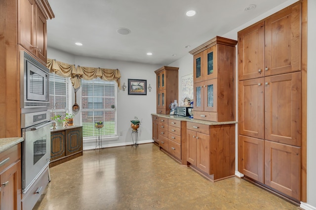 kitchen with light stone counters and appliances with stainless steel finishes