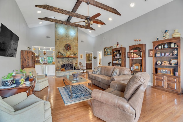 living room with a fireplace, light hardwood / wood-style floors, beamed ceiling, and high vaulted ceiling