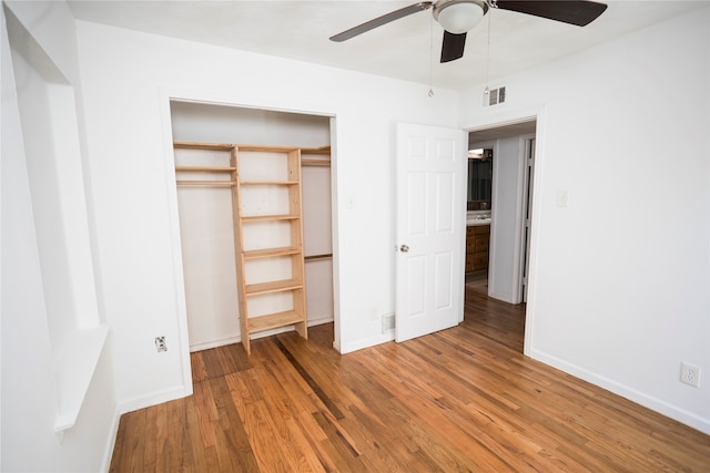 unfurnished bedroom with hardwood / wood-style floors, ceiling fan, and a closet