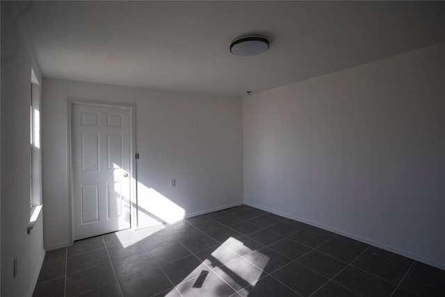 unfurnished room with dark tile patterned floors