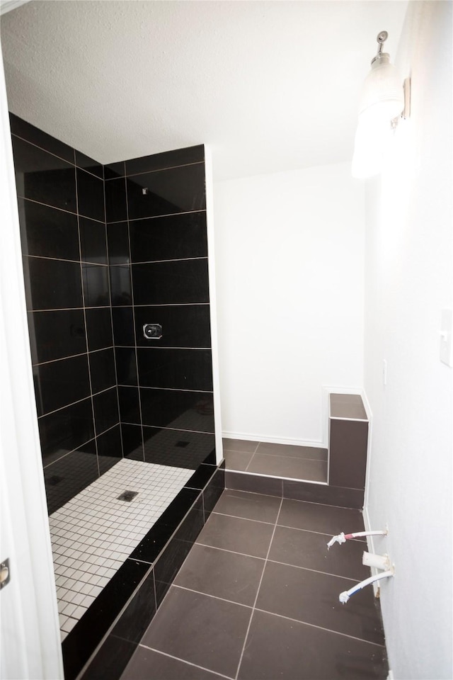 bathroom with tiled shower and tile patterned floors