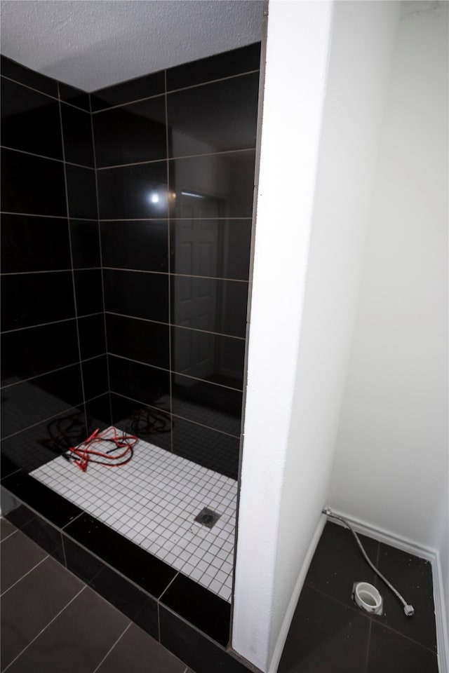 bathroom featuring tile patterned floors, a textured ceiling, and a tile shower