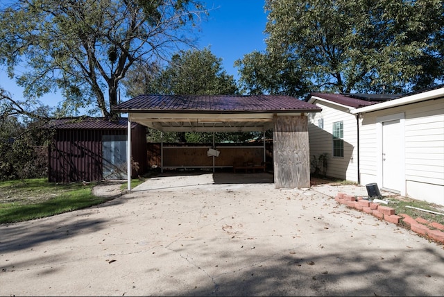 view of patio / terrace with an outbuilding and a carport