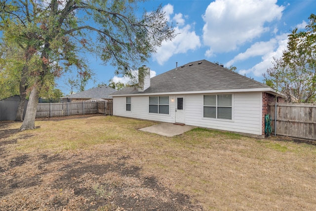 rear view of house featuring a patio and a yard