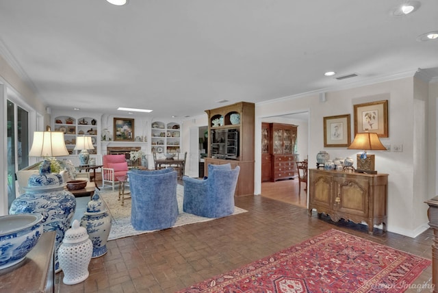 living room featuring built in shelves and ornamental molding