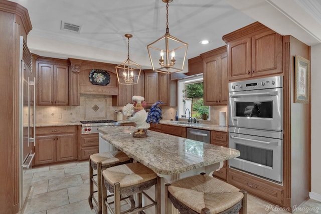341 Corinne Cir, Shreveport, LA 71106 - kitchen with pendant lighting, sink, appliances with stainless steel finishes, a center island, and light stone counters