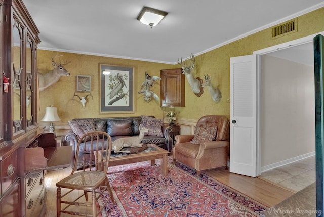 living room with light wood-type flooring and ornamental molding