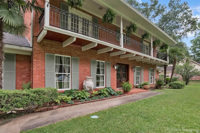 view of front of property with a balcony and a front lawn