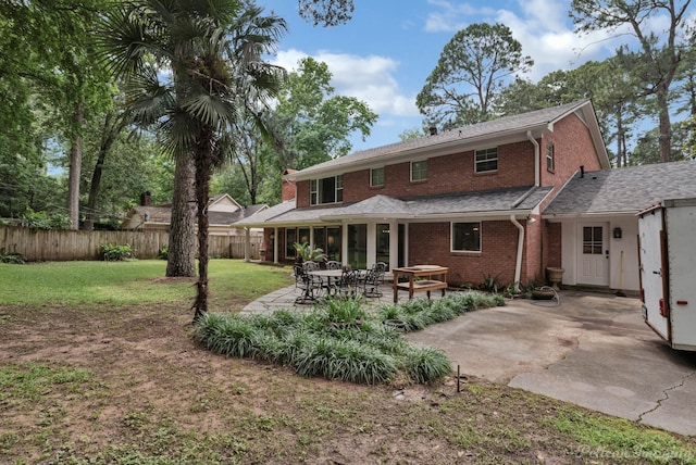 rear view of house featuring a patio and a lawn