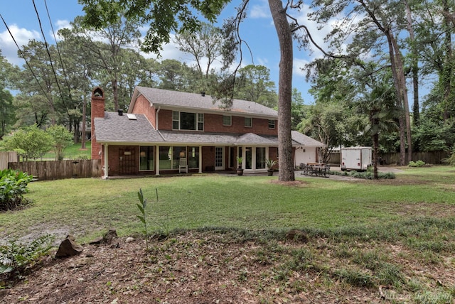 back of property featuring a storage shed and a yard