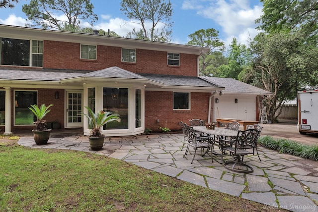 back of property featuring a patio area and a lawn