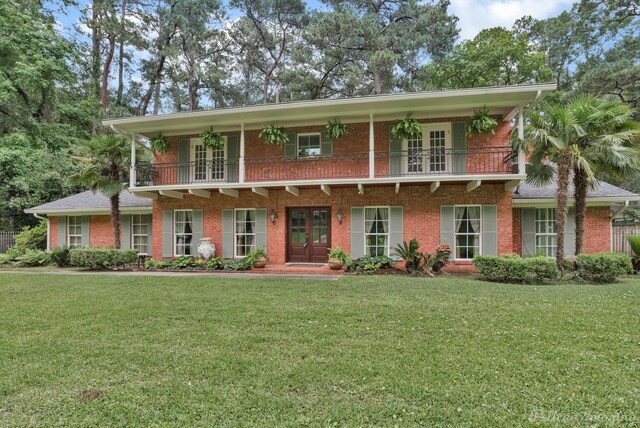 view of front of house with a front lawn and a balcony