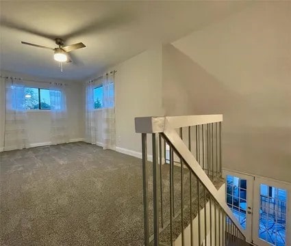 interior space featuring ceiling fan and dark colored carpet