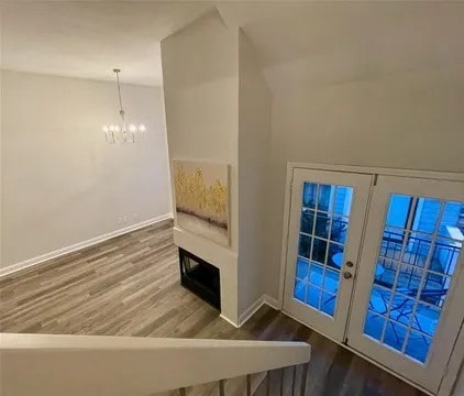 entryway featuring an inviting chandelier, hardwood / wood-style floors, and french doors