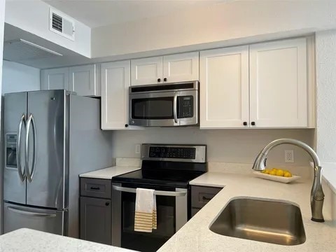 kitchen featuring white cabinetry, stainless steel appliances, and sink