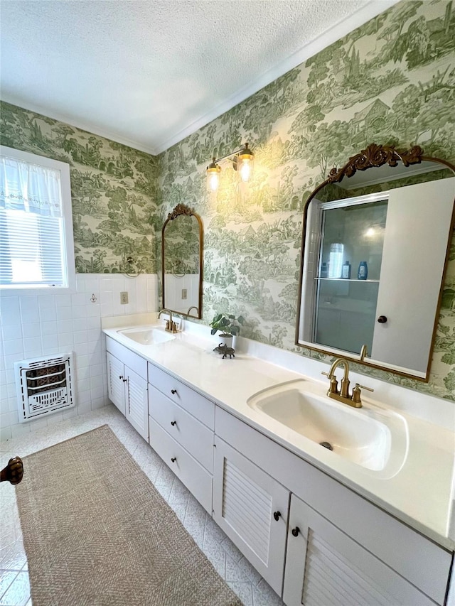 bathroom with heating unit, tile patterned flooring, vanity, and a textured ceiling