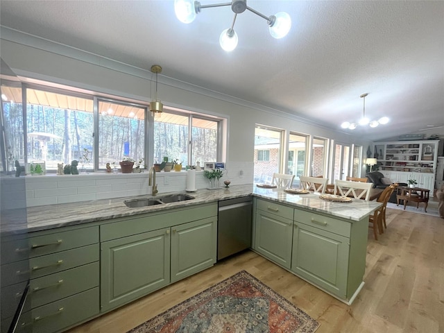 kitchen with kitchen peninsula, sink, an inviting chandelier, green cabinetry, and hanging light fixtures