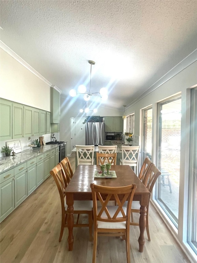 dining room featuring ceiling fan, light hardwood / wood-style floors, a healthy amount of sunlight, and ornamental molding