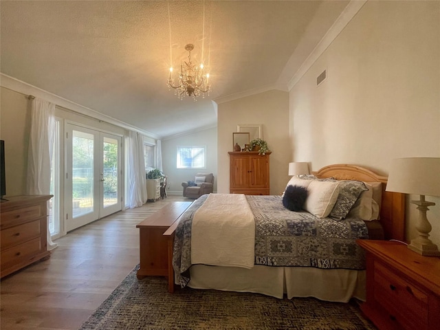 bedroom featuring access to exterior, french doors, crown molding, vaulted ceiling, and hardwood / wood-style flooring