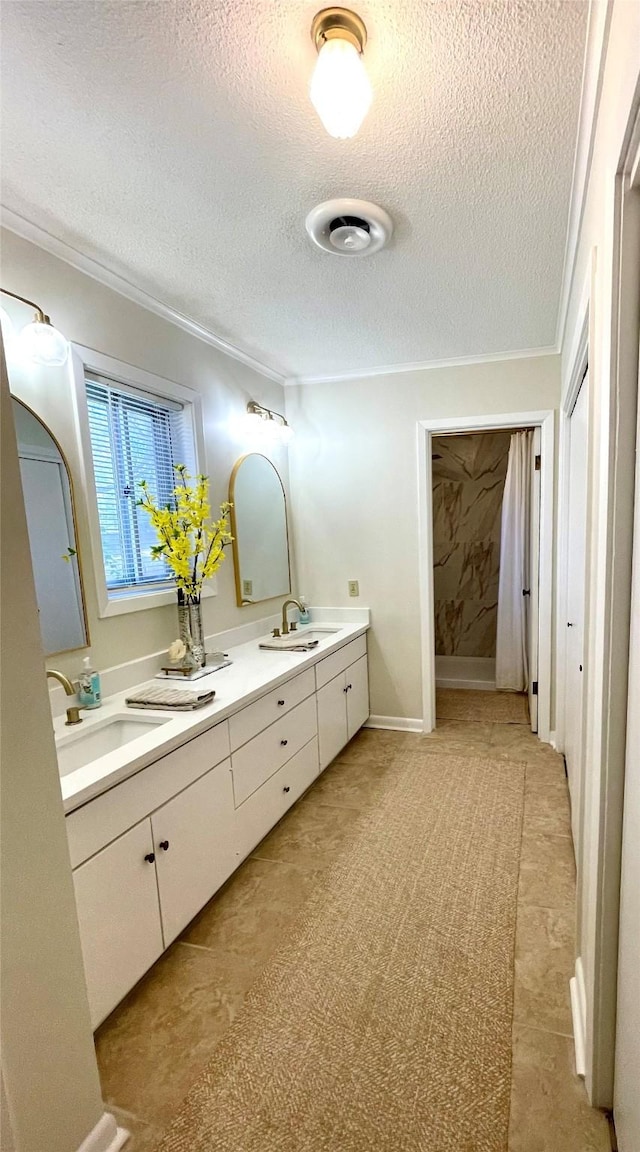 bathroom featuring vanity, ornamental molding, and a textured ceiling