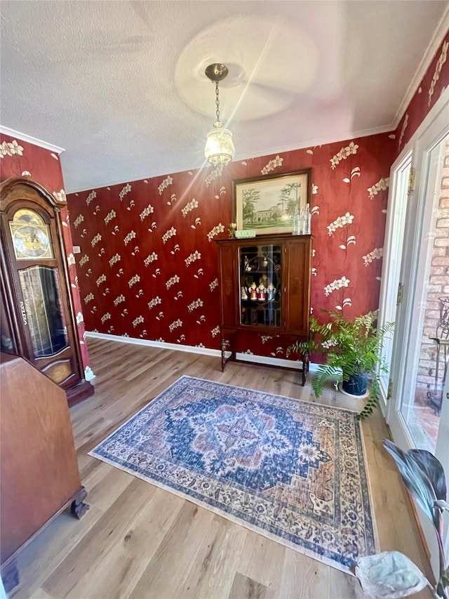 living room with hardwood / wood-style floors, a textured ceiling, and crown molding