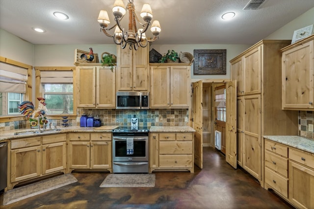 kitchen featuring stainless steel appliances, sink, light stone counters, and backsplash