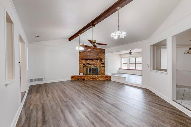 unfurnished living room with a brick fireplace, dark hardwood / wood-style floors, vaulted ceiling with beams, and ceiling fan with notable chandelier