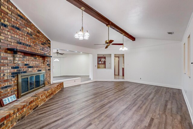 unfurnished living room featuring lofted ceiling with beams, hardwood / wood-style floors, ceiling fan with notable chandelier, and a brick fireplace