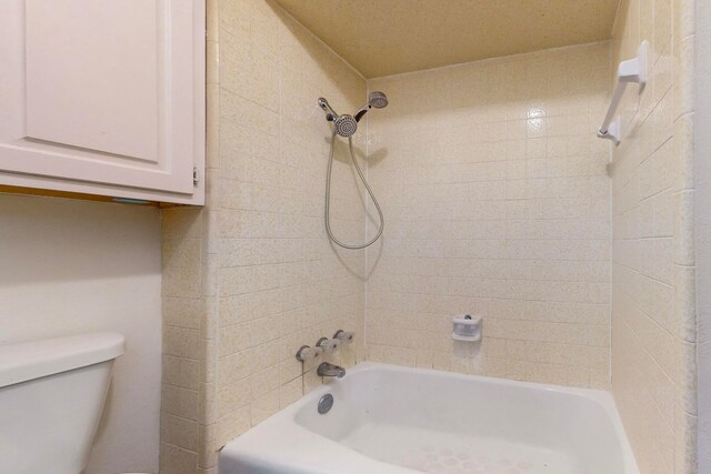 bathroom with tiled shower / bath and toilet