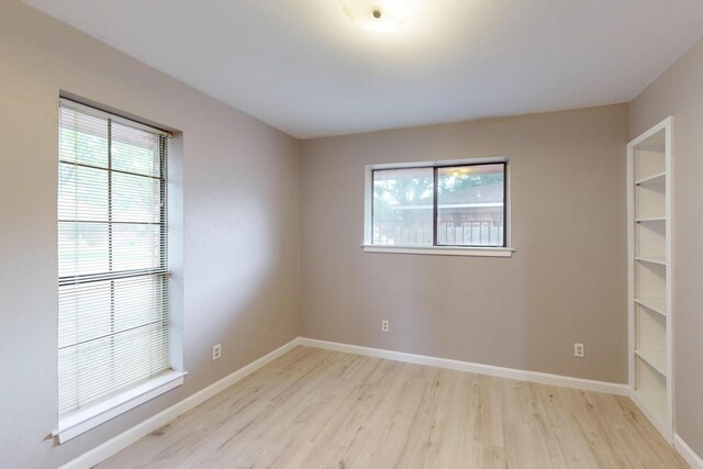 unfurnished room featuring light wood-type flooring and a healthy amount of sunlight