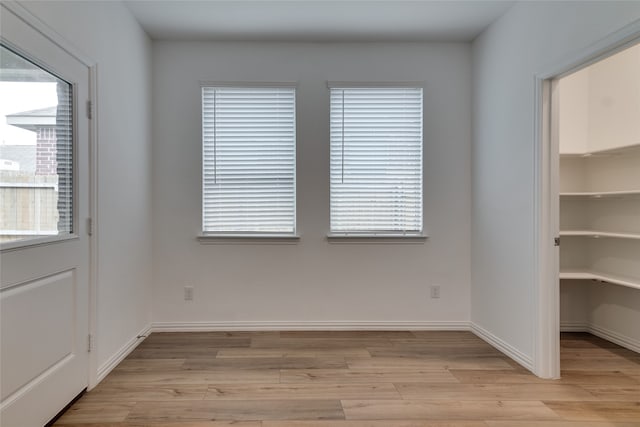 spare room with a healthy amount of sunlight and light hardwood / wood-style flooring