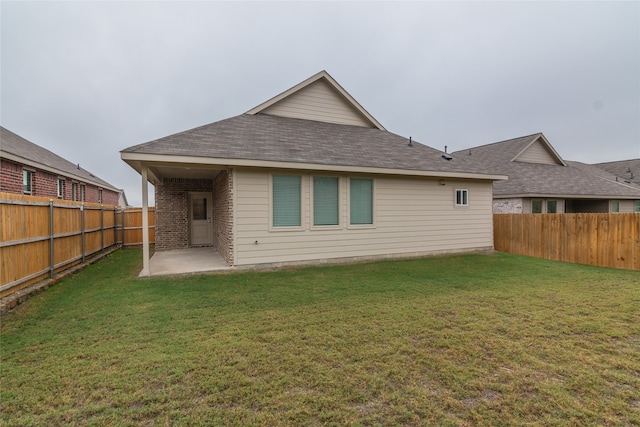 back of house featuring a patio area and a lawn