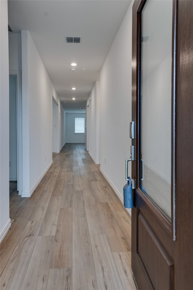 hallway with light hardwood / wood-style flooring