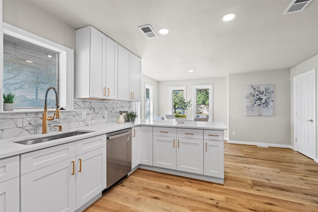 kitchen with sink, stainless steel dishwasher, white cabinets, and decorative backsplash