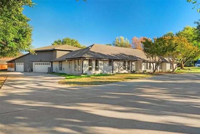 view of front of property with a garage and central AC