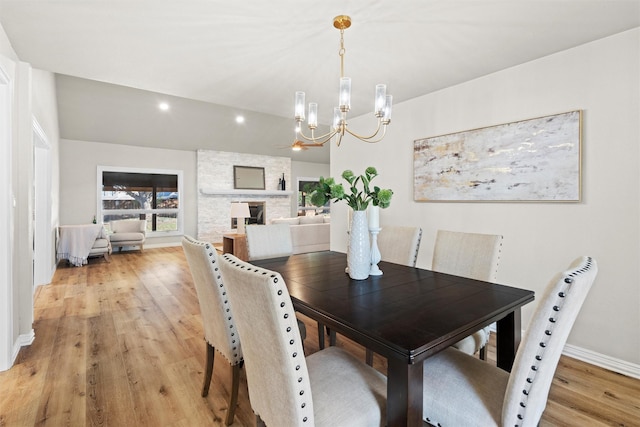 dining area featuring lofted ceiling, light hardwood / wood-style flooring, and a chandelier