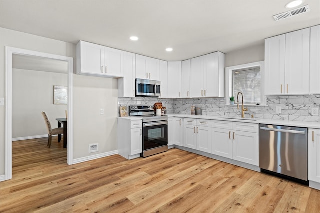 kitchen featuring white cabinetry, sink, and appliances with stainless steel finishes