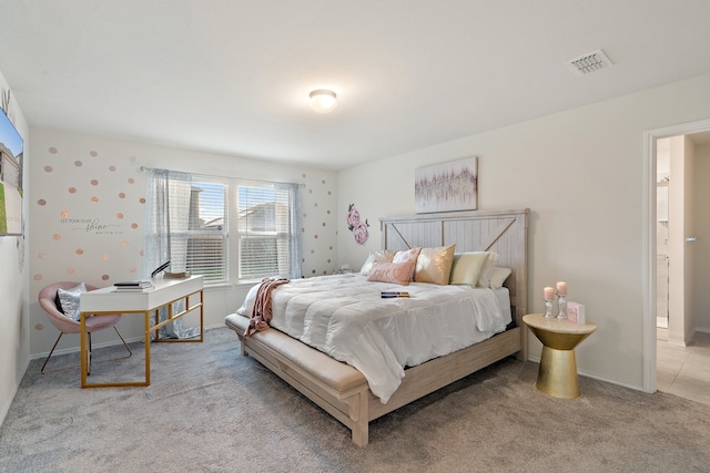 bedroom featuring light carpet and connected bathroom