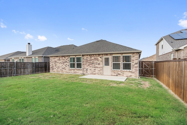 back of house featuring a patio area and a lawn