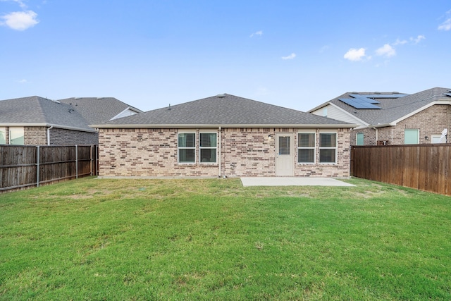 back of property with a lawn and a patio area