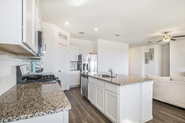 kitchen featuring sink, backsplash, a kitchen island with sink, white cabinets, and appliances with stainless steel finishes