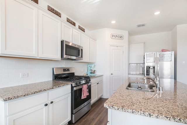 kitchen featuring appliances with stainless steel finishes, white cabinetry, and sink